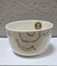 White ceramic cup with gold accents on a white background